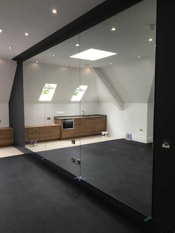 Frameless glass partition in loft conversion by Notting Hill glaziers