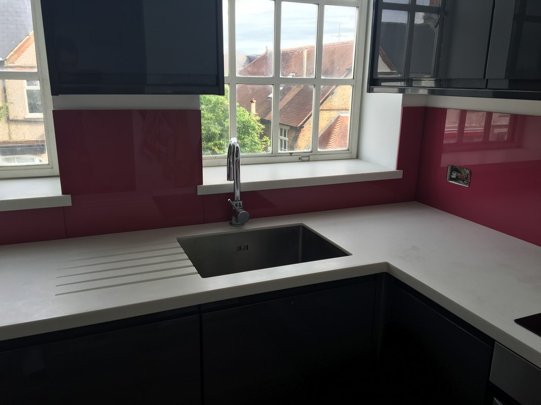 Deep plum coloured glass splashback in modern Notting Hill kitchen